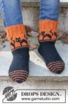 Children 47-29 Spooky Sunset Socks by DROPS Design — Calcetines: 24/25, 26/28, 29/31, 32/34, 35/37, 38/40 y 41/43; pie: 15, 17, 18, 20, 22, 24 y 26 cm. También agujas de doble punta de 2,5 mm y restos amarillos para los ojos. Se incluye un ovillo completo de mostaza oscuro 52 para los ojos amarillos; puede diferir del tono de las fotos. — 1
